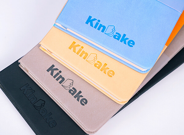 a small batch of notebooks in various colors with embossed logo